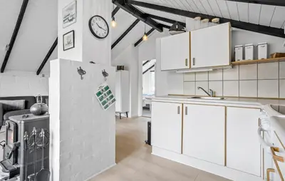 a kitchen with white cabinets and a clock on the wall at 2 Bedroom Amazing Home In Thisted in Thisted