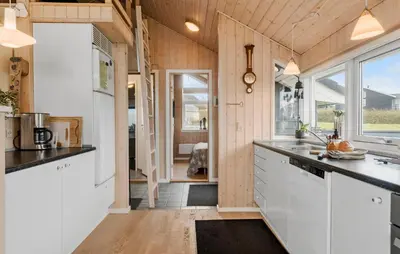 a kitchen with white cabinets and a large window at Cozy Home In Lemvig With Sauna in Lemvig
