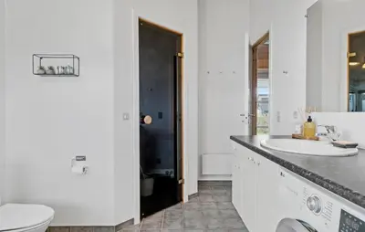 a white bathroom with a sink and a toilet at Cozy Home In Lemvig With Sauna in Lemvig