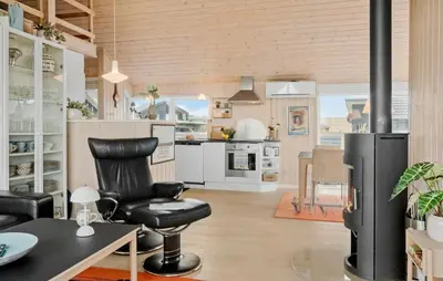 a kitchen with a black chair and a table at Cozy Home In Lemvig With Sauna in Lemvig