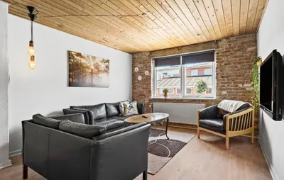 a living room with leather furniture and a brick wall at Lovely Home In Bøvlingbjerg With Wifi in Bøvlingbjerg