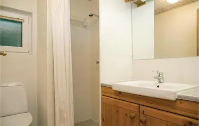 a bathroom with a sink and a toilet and a mirror at Holiday Home Blokhus With Sauna 156 in Blokhus