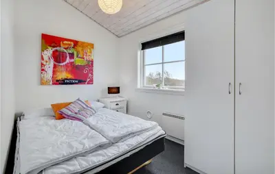 a bedroom with a bed and a painting on the wall at 3 Bedroom Amazing Home In Vinderup in Vinderup