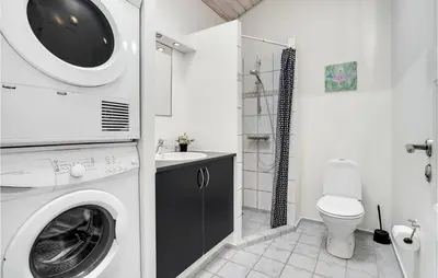 a bathroom with a washing machine and a toilet at 3 Bedroom Amazing Home In Vinderup in Vinderup