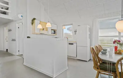 a white kitchen with a table and a white refrigerator at Nice Home In Frøstrup With Kitchen in Frøstrup