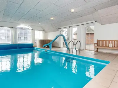 a swimming pool with a slide in a building at Luxury Beach Retreat - By Traum Ferienwohnungen in Harboør