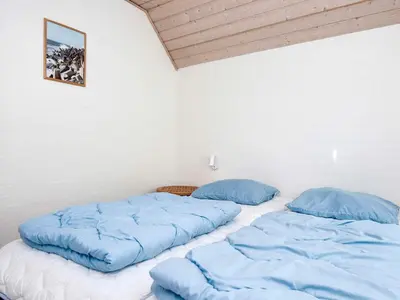 two beds in a room with blue pillows at Luxury Beach Retreat - By Traum Ferienwohnungen in Harboør