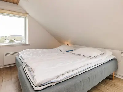 a large bed in a room with a window at Seaside Escape with Views - By Traum Ferienwohnungen in Vestervig