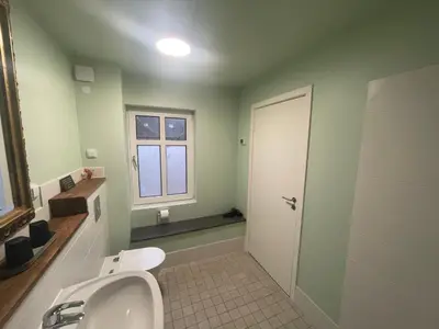a bathroom with a sink and a toilet and a window at Wohnung in Salling in Buksager