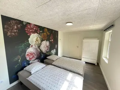 a bedroom with two beds and a flower mural at Wohnung in Salling in Buksager