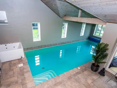 an indoor swimming pool in a house with a ceiling at Luxury Lodge with Limfjord View - By Traum Ferienwohnungen in Spottrup