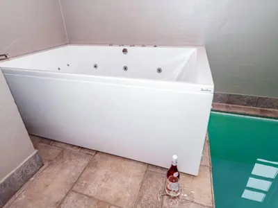 a white bath tub in a bathroom with a bottle of champagne at Luxury Lodge with Limfjord View - By Traum Ferienwohnungen in Spottrup