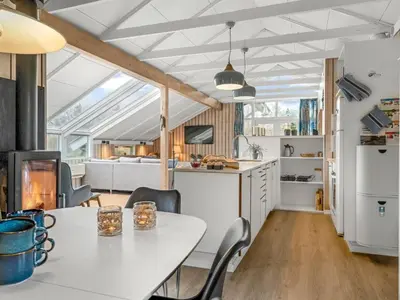 a kitchen and dining room with a white table and chairs at Holiday Home Wilmer - 600m from the sea by Interhome in Løkken