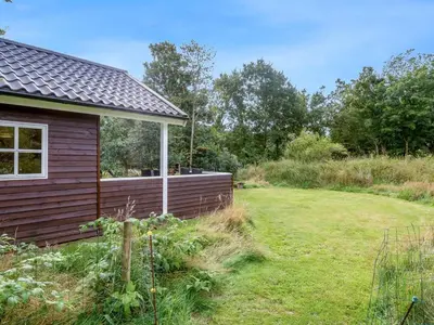 a garden with a house and a yard at Holiday Home Unge - 2-9km from the sea by Interhome in Blokhus
