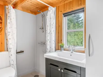 a bathroom with a sink and a window at Holiday Home Unge - 2-9km from the sea by Interhome in Blokhus