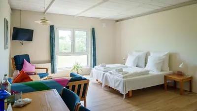 a bedroom with a bed and a couch and a window at Morup Mølle Kro in Bedsted Thy