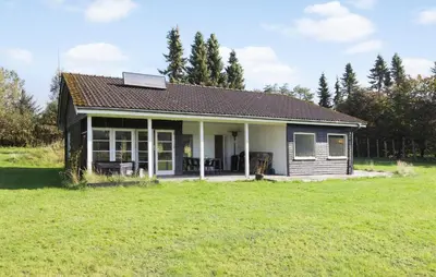 a small house with a green field in front of it at 3 Bedroom Beautiful Home In Roslev in Roslev