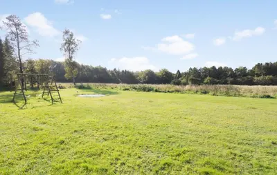 an empty field with a swing set in the grass at 3 Bedroom Beautiful Home In Roslev in Roslev