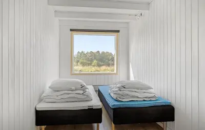 two twin beds in a room with a window at 3 Bedroom Beautiful Home In Roslev in Roslev