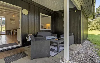 a patio with a table and chairs on a house at 3 Bedroom Beautiful Home In Roslev in Roslev