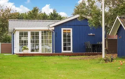 a blue shed with a porch and a lawn at 3 Bedroom Beautiful Home In Thyholm in Thyholm