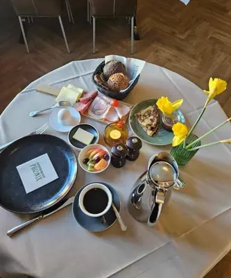 a table with breakfast foods on a white table cloth at B&B Phønix in Holstebro