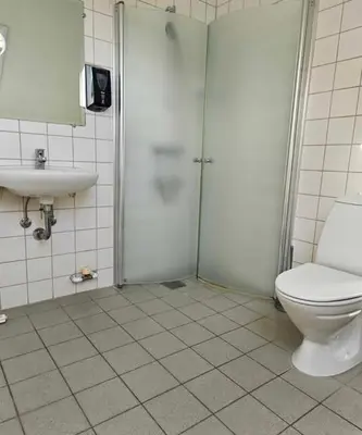 a bathroom with a shower and a toilet and a sink at B&B Phønix in Holstebro