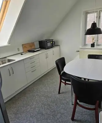 a kitchen with a table and some chairs and a table at B&B Phønix in Holstebro