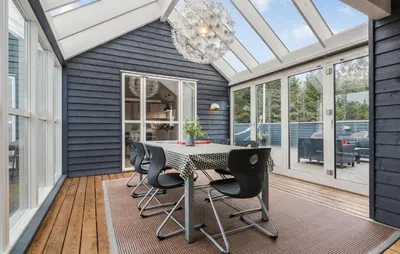 a conservatory with a table and chairs on a deck at Beautiful Home In Farsø With Wifi in Farsø