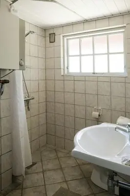 a bathroom with a tub and a sink and a window at Summer House For The Big Family Close To The Fjord in Agger