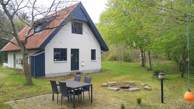 a table and chairs in front of a house at Summer House For The Big Family Close To The Fjord in Agger