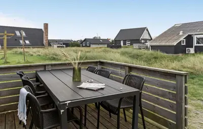 a table with chairs and a vase on a deck at 2 Bedroom Nice Home In Thisted in Thisted