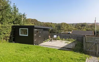 a small black shed in a yard next to a fence at 2 Bedroom Lovely Home In Thisted in Thisted