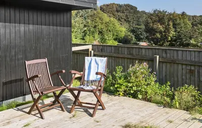 two rocking chairs sitting on a wooden deck at 2 Bedroom Lovely Home In Thisted in Thisted