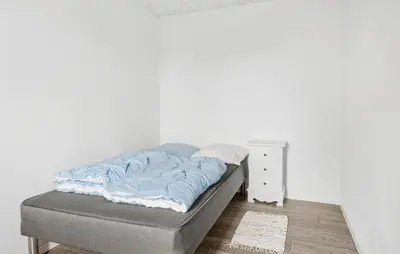 a bed in a room with a white wall at 4 Bedroom Nice Home In Harboøre in Harboør