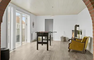 a living room with a ping pong table and a chair at 4 Bedroom Nice Home In Harboøre in Harboør
