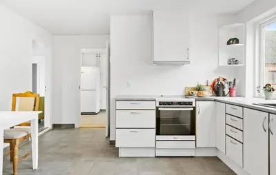 a white kitchen with white appliances and a table at 4 Bedroom Nice Home In Harboøre in Harboør