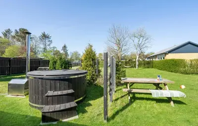 a picnic table and a trash can in a yard at Det gamle forsamlinghus in Struer
