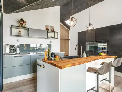 a kitchen with white and black cabinets and a counter at Holiday Home Jahn - 250m to the fjord by Interhome in Højslev