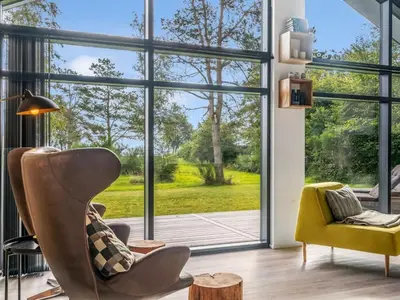 a living room with a large window and a yellow chair at Holiday Home Jahn - 250m to the fjord by Interhome in Højslev