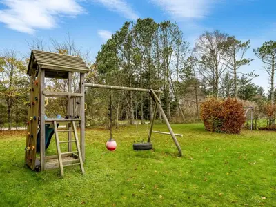 a playground with a swing and a ladder at Holiday Home Tammo - 1-1km from the sea by Interhome in Blokhus