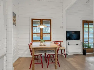 a dining room with a wooden table and chairs at Holiday Home Tammo - 1-1km from the sea by Interhome in Blokhus