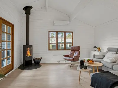 a living room with a couch and a fireplace at Holiday Home Tammo - 1-1km from the sea by Interhome in Blokhus