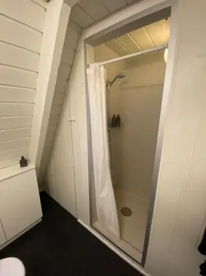a bathroom with a shower with a shower curtain at Skønt Sommerhus Golfhytte midt i skønne omgivelser in Gatten