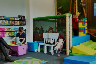 two children playing in a room with play equipment at Skønt Sommerhus Golfhytte midt i skønne omgivelser in Gatten