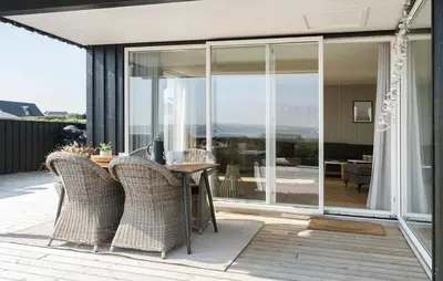 a patio with glass doors and a table and chairs at Cozy Home In Lemvig With Wifi in Lemvig
