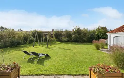 a yard with a chair and a swing at Lovely Home In Blokhus With Wifi in Blokhus