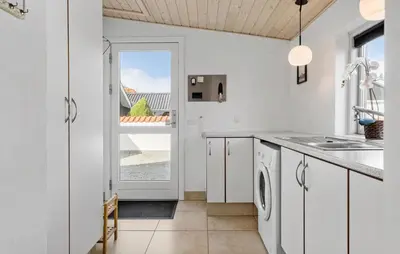 a kitchen with white cabinets and a sink and a window at Lovely Home In Blokhus With Wifi in Blokhus
