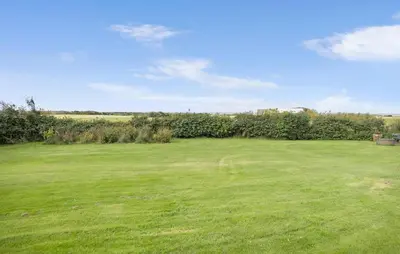 a large grassy field with a fence and trees at 4 Bedroom Gorgeous Home In Vestervig in Vestervig