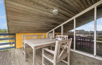 a wooden table and chairs on a deck at Pet Friendly Home In Thisted With Sauna in Thisted